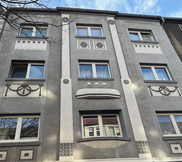 Mehrfamilienhaus mit grauer Stuckfassade